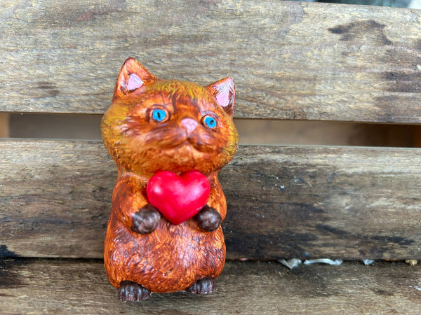 Cat holding heart